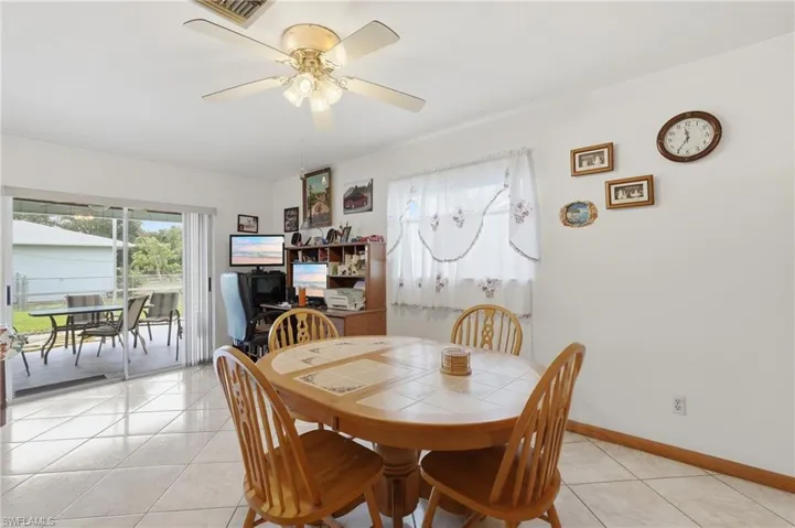 Bright interior space featuring light-toned tile flooring and a ceiling fan with integrated lighting