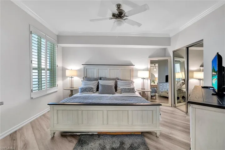 Bedroom featuring ceiling fan, light hardwood / wood-style floors, and crown molding