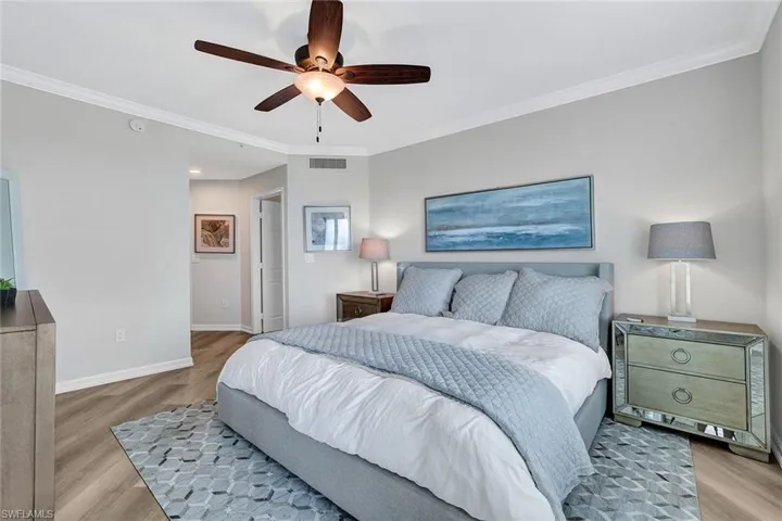 Bedroom featuring ceiling fan, crown molding, and light wood-type flooring