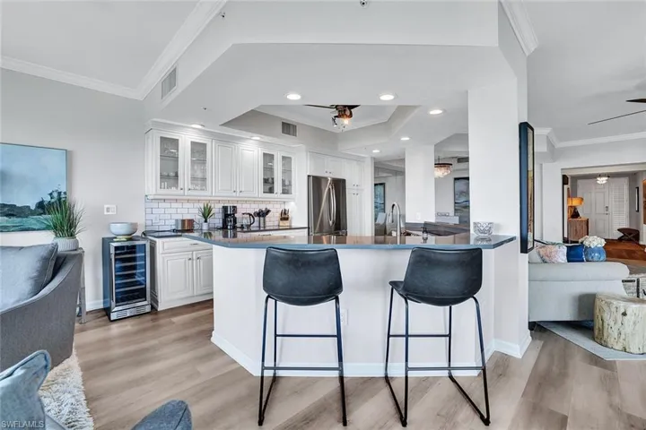 Kitchen featuring stainless steel refrigerator, wine cooler, ceiling fan, and light hardwood / wood-style floors