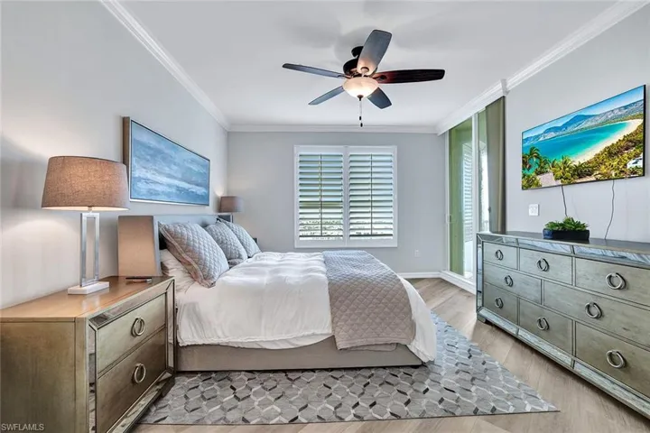 Bedroom featuring ceiling fan, crown molding, and light wood-type flooring