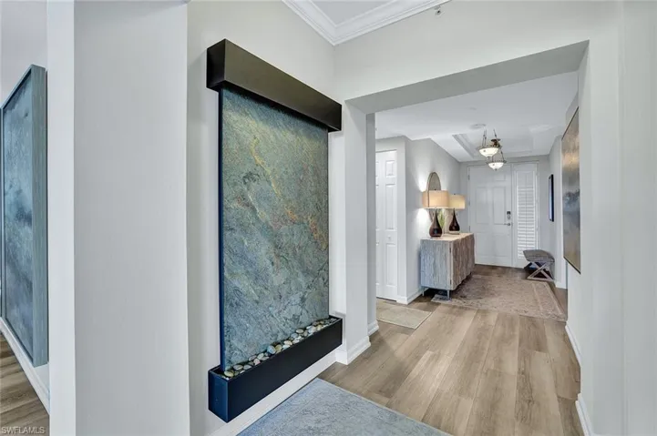 Hall featuring light hardwood / wood-style flooring and ornamental molding