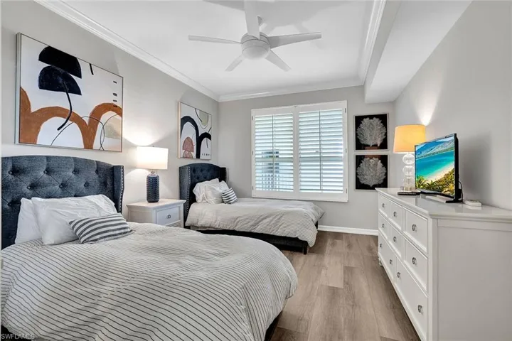 Bedroom with crown molding, ceiling fan, and light hardwood / wood-style floors