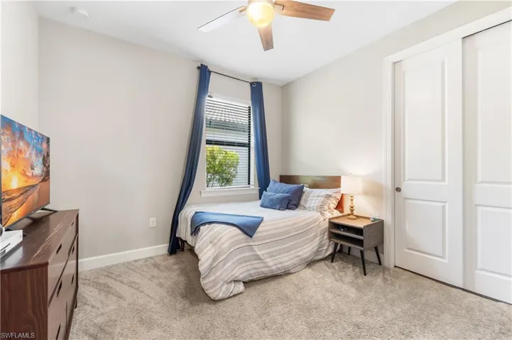 Bedroom with light carpet and a ceiling fan