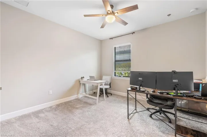 Carpeted office with baseboards and ceiling fan