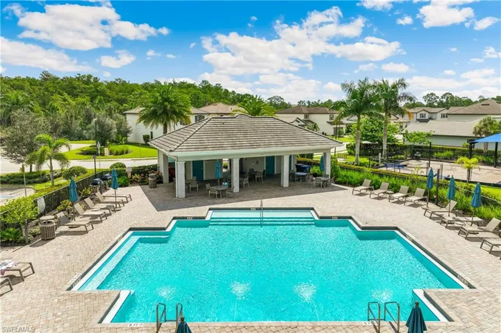 Community pool with a patio area and a residential view