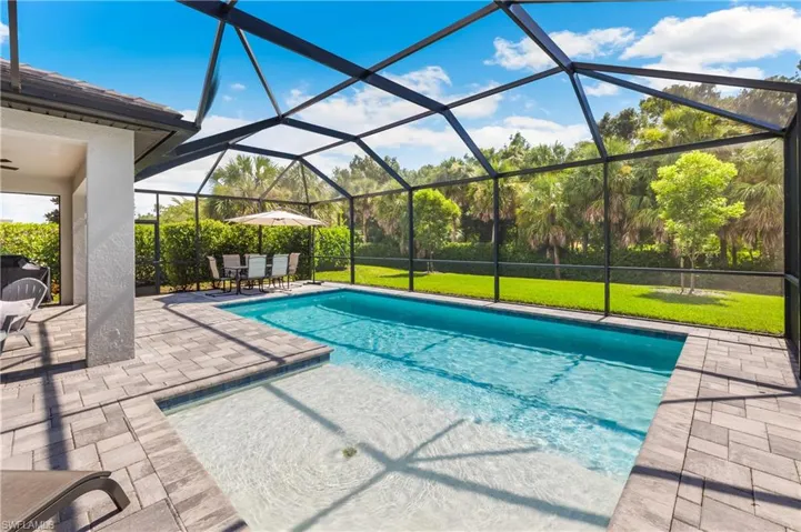 Swimming pool featuring a patio, a lanai, a lawn, and outdoor dining area