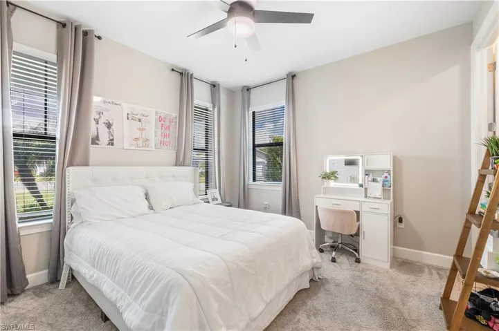 Bedroom featuring light carpet, a desk, and ceiling fan