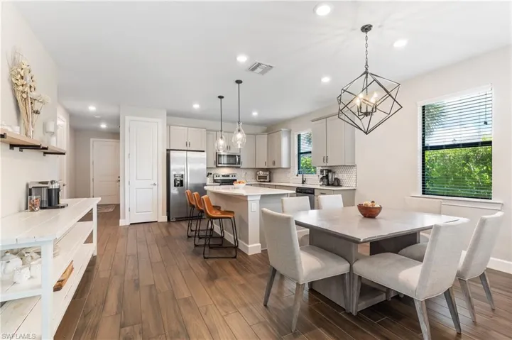 Dining space featuring dark wood-style floors, recessed lighting, and a chandelier