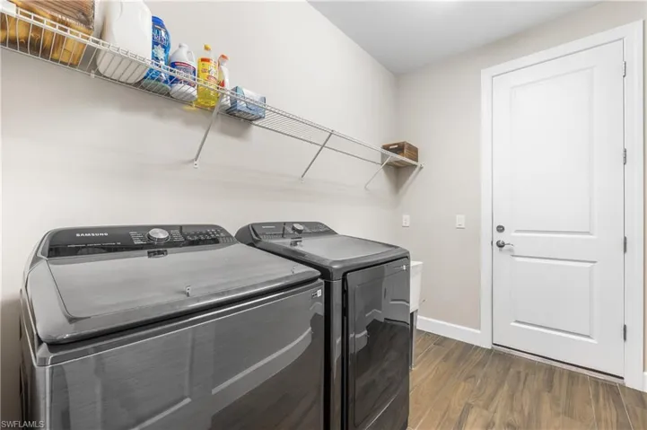 Laundry room with separate washer and dryer and dark wood-style flooring