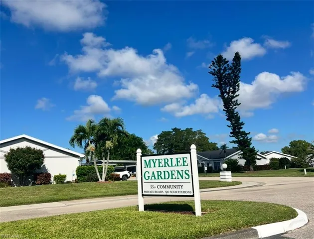 Community / neighborhood sign featuring a yard
