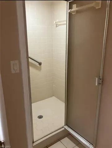 Bathroom featuring light tile patterned flooring and a stall shower
