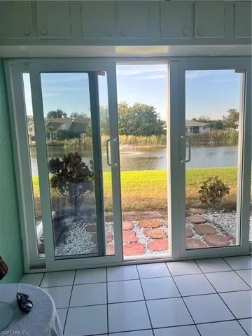 Doorway with a water view and tile patterned flooring