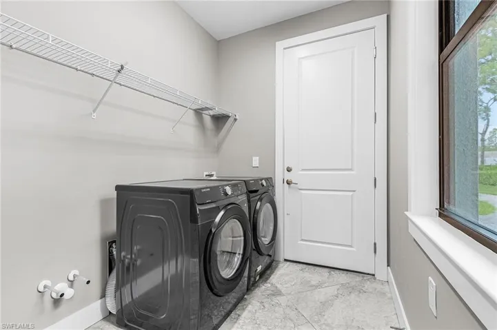 Washroom featuring healthy amount of natural light and separate washer and dryer