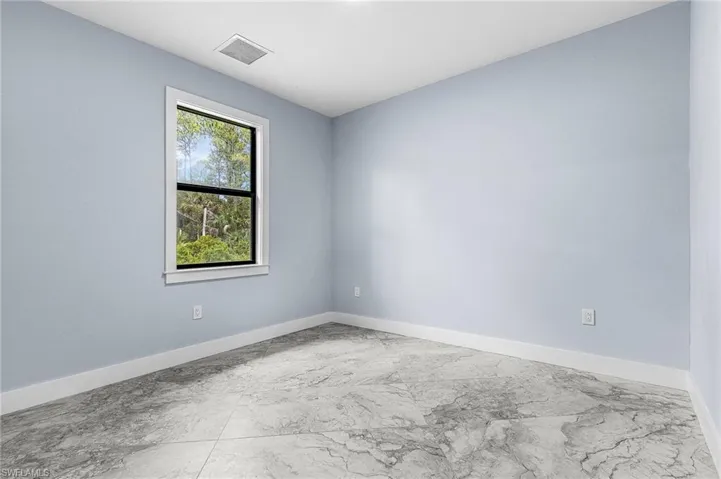 Unfurnished room featuring baseboards and marble finish floors