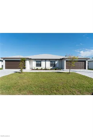 Ranch-style home featuring a garage and a front lawn