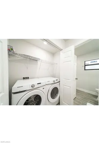 Laundry area featuring light wood-type flooring and washing machine and dryer