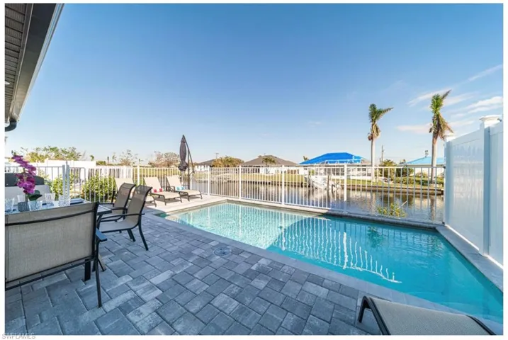 View of swimming pool featuring a water view and a patio area