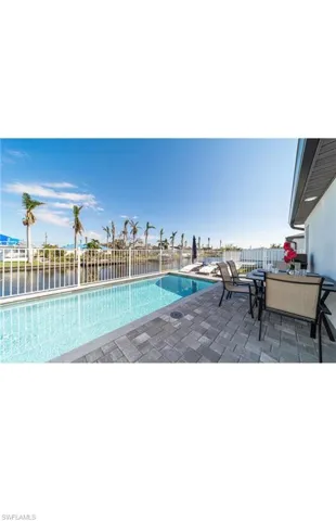 View of swimming pool with a patio area and a water view
