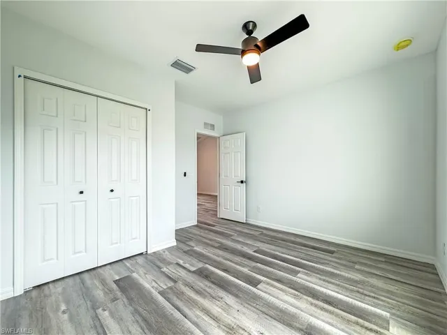 Unfurnished bedroom with a ceiling fan, a closet, and wood finished floors