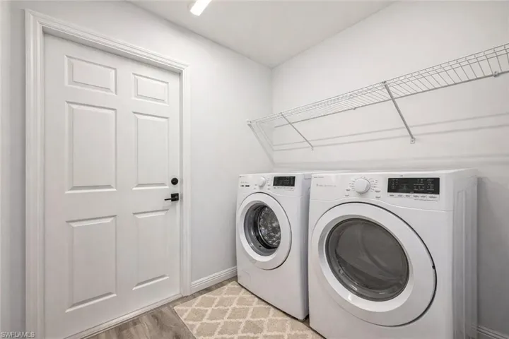 Laundry area featuring separate washer and dryer and light wood-style flooring