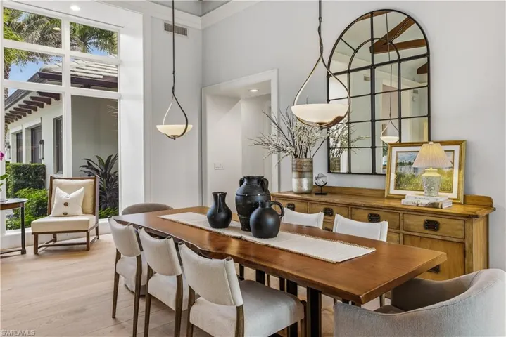 Dining area featuring wood finished floors, a towering ceiling, and recessed lighting