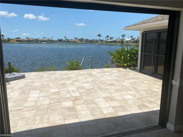 View of patio with a water view and a boat dock