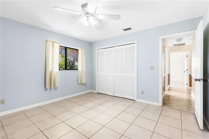Unfurnished 2nd Guest bedroom featuring light tile patterned floors, a closet, and ceiling fan