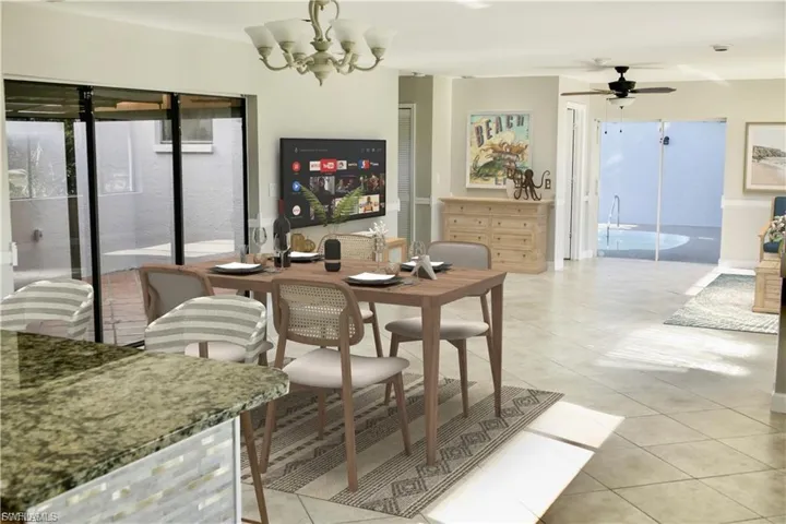 Dining room with light tile patterned floors, a ceiling fan, and a chandelier
