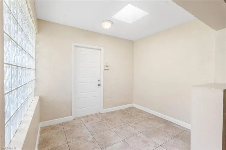 Spare room featuring a skylight and light tile patterned floors