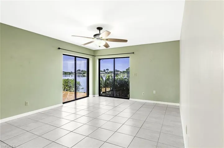 Unfurnished Primary room featuring light tile patterned floors, a water view, and a ceiling fan