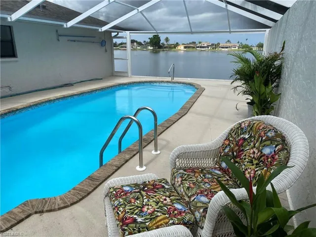 Outdoor pool with a patio area, a sunroom, a water view, and a lanai