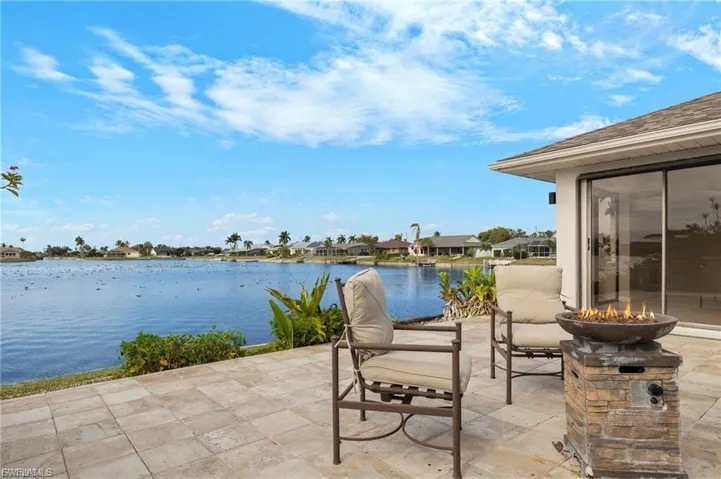 View of patio / terrace with an outdoor fire pit, a water view, and a residential view