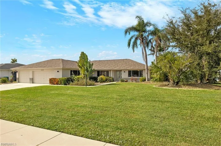 Single story home with a front yard, concrete driveway, stucco siding, and a garage