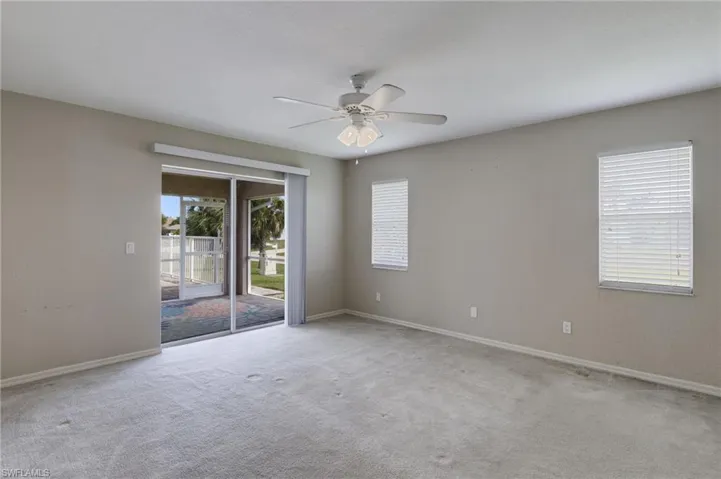 Unfurnished room featuring a ceiling fan and light colored carpet