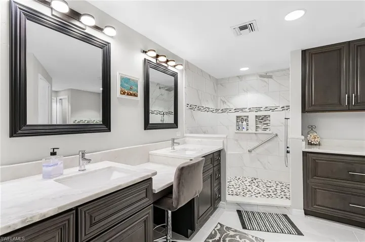 Bathroom with double vanity, walk in shower, light tile patterned floors, and recessed lighting