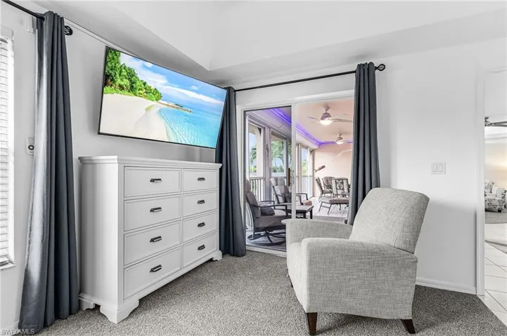 Living area with light carpet and a ceiling fan
