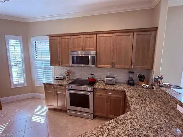 Kitchen with new cabinets, stainless steel appliances, granite counters and tasteful backsplash