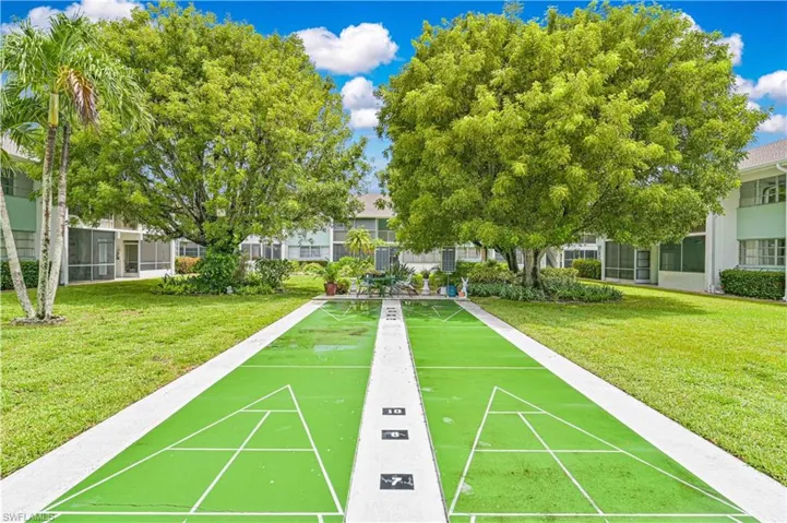 View of community with a yard and shuffleboard
