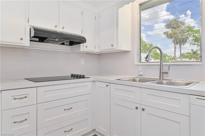 Kitchen with freestanding refrigerator, stainless steel oven, white cabinets, dark wood finished floors, and recessed lighting