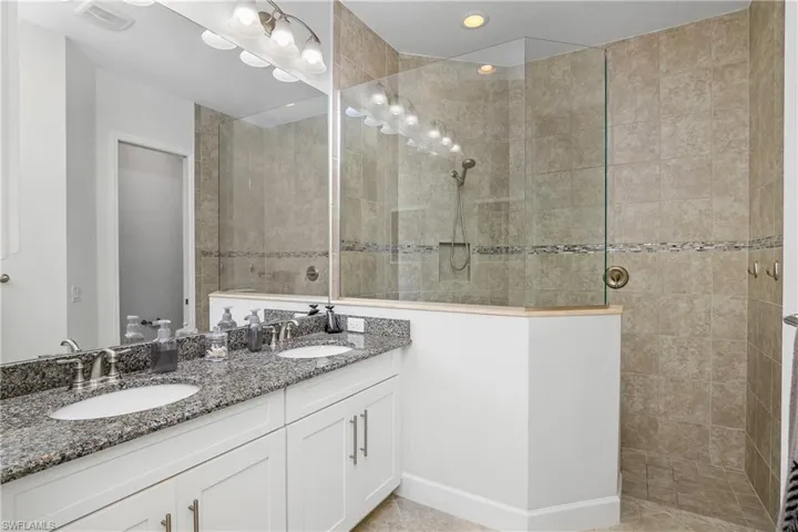 Owner's bath includes dual sinks, large walk-in shower with frameless glass enclosure, and spacious his/her closets.