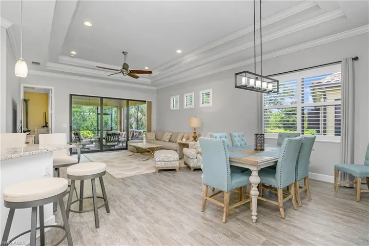 Open kitchen/dining/great room with soaring ceilings includes tray ceilings, porcelain tile floors, and plenty of natural light.