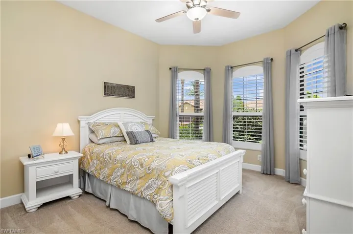 Guest bedroom located at the front of the home provides plenty of natural light and plantation shutters.