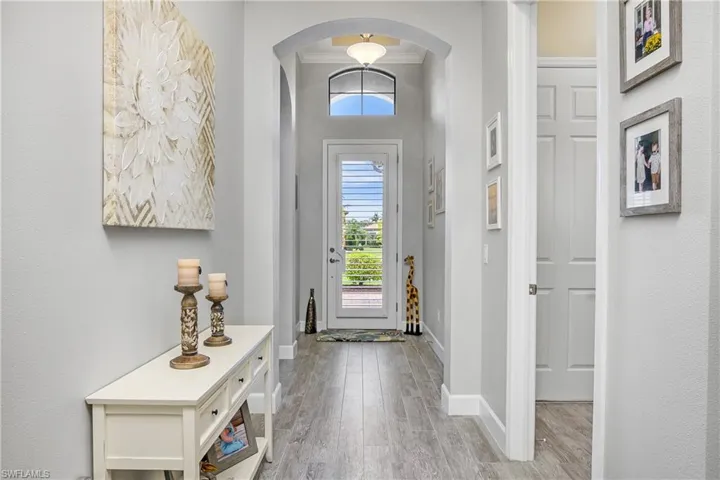 Welcoming entry foyer featuring high ceilings, crown molding, and beautiful archways leading to the open family space.
