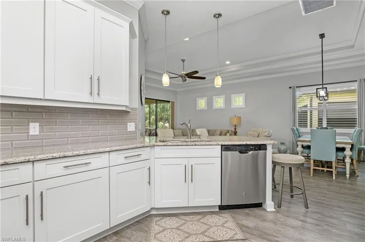 Upgraded white cabinetry, decorative backsplash, tray ceiling, and open floor plan make this home perfect for family gatherings.