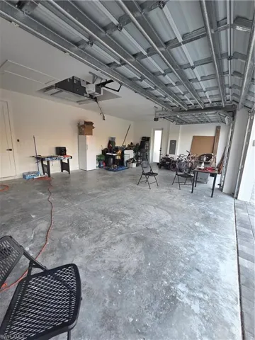 Garage featuring refrigerator and a garage door opener