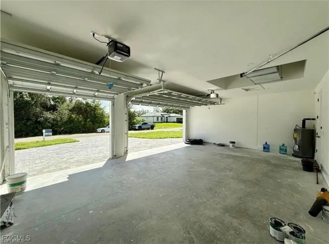 Garage featuring water heater and a garage door opener