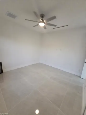 Unfurnished room featuring baseboards and ceiling fan