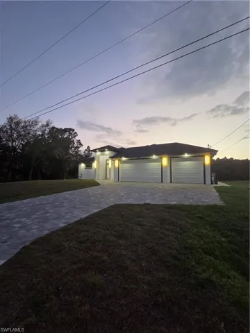 View of front of property with a lawn, decorative driveway, and stucco siding