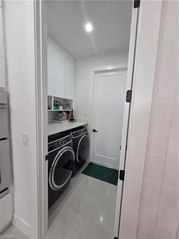 Laundry area featuring separate washer and dryer and cabinet space